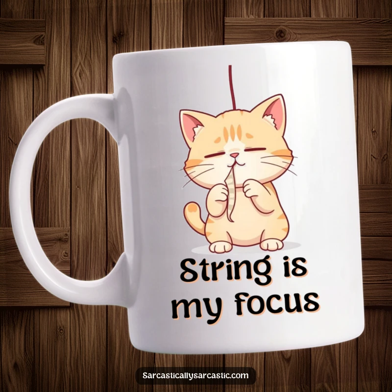Funny cat mug with narrowed eyes, playfully batting at a dangling string, capturing intense focus, a funny gift.