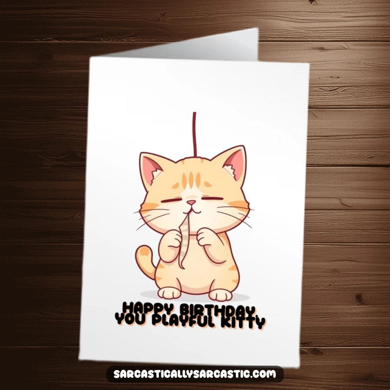 Funny Free Printable Birthday Card: A cat with narrowed eyes playfully bats at a dangling string, ready for birthday fun.